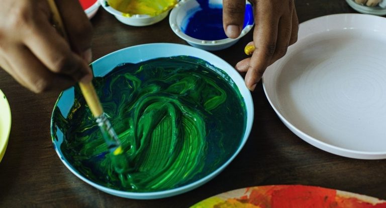 Personne melangeant des peintures colorees pour obtenir une nouvelle teinte
