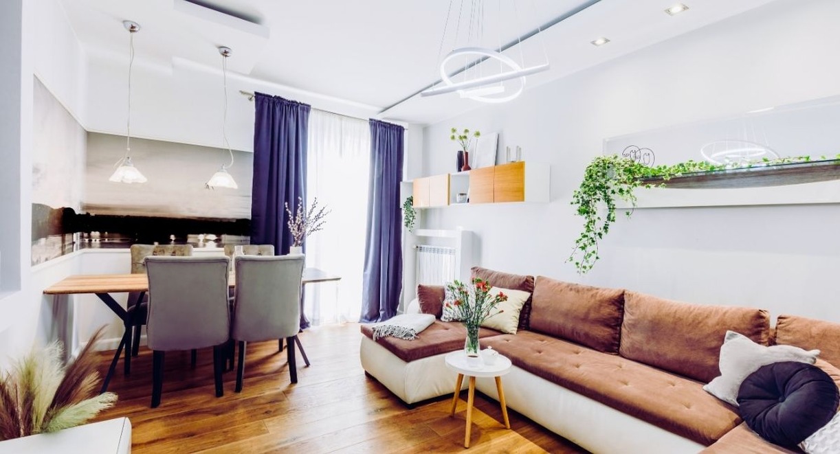Petit salon avec canape d'angle marron et coin repas ouvert