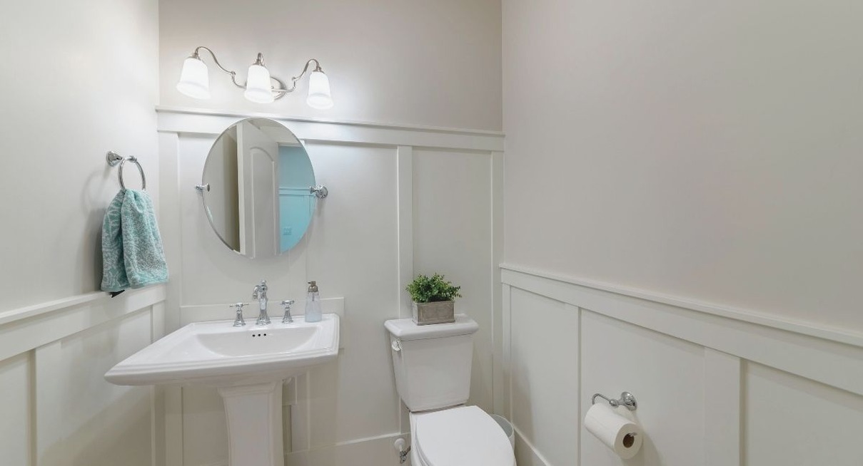 Salle de bain habillee d'un panneau mural blanc autour du lavabo